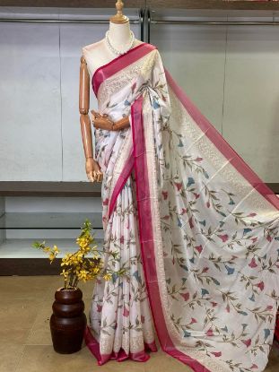 Show details for A white saree with a floral print and a pink border, draped on a mannequin Picture of A white saree with a floral print and a pink border, draped on a mannequin